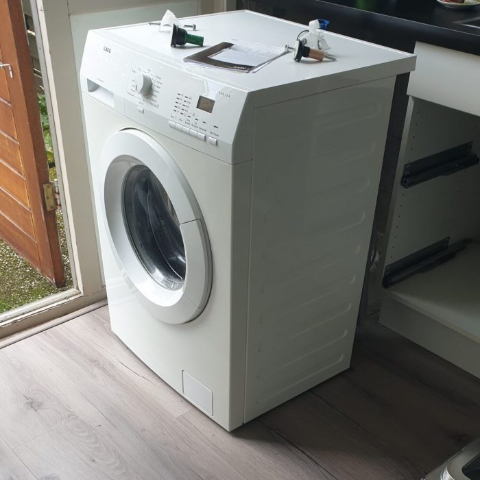 De oude wasmachine staat klaar om opgehaald te worden