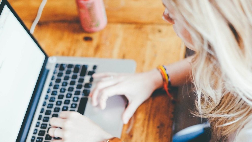 Vrouw achter laptop die het druk heeft.