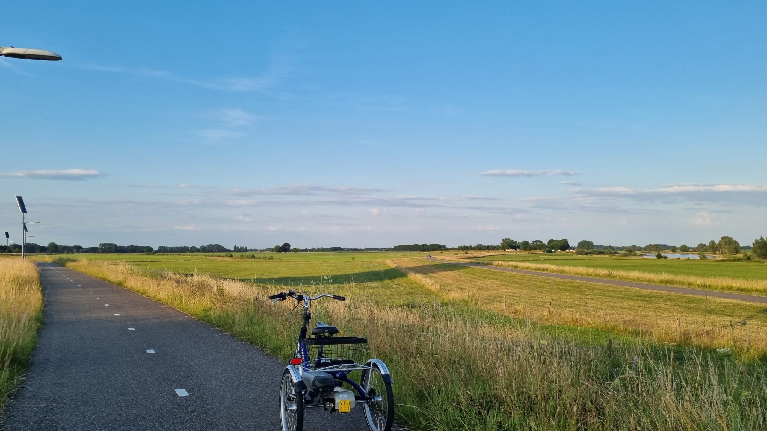 Fietsen met mijn driewielfiets op de dijk in Cortenoever, Gemeente Brummen met op de achtergrond de IJssel.