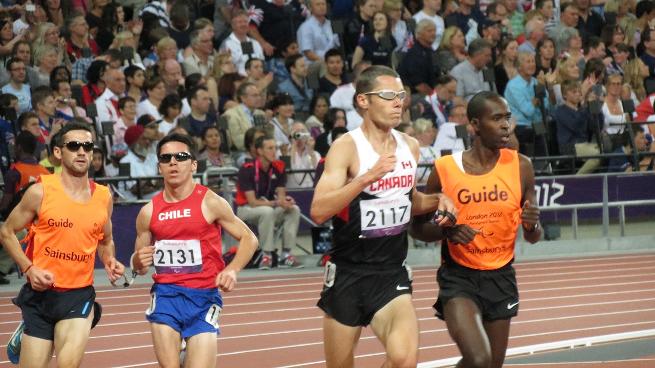 Blinde hardlopers met hun guides op de atletiekbaan tijdens de Paralympische Spelen